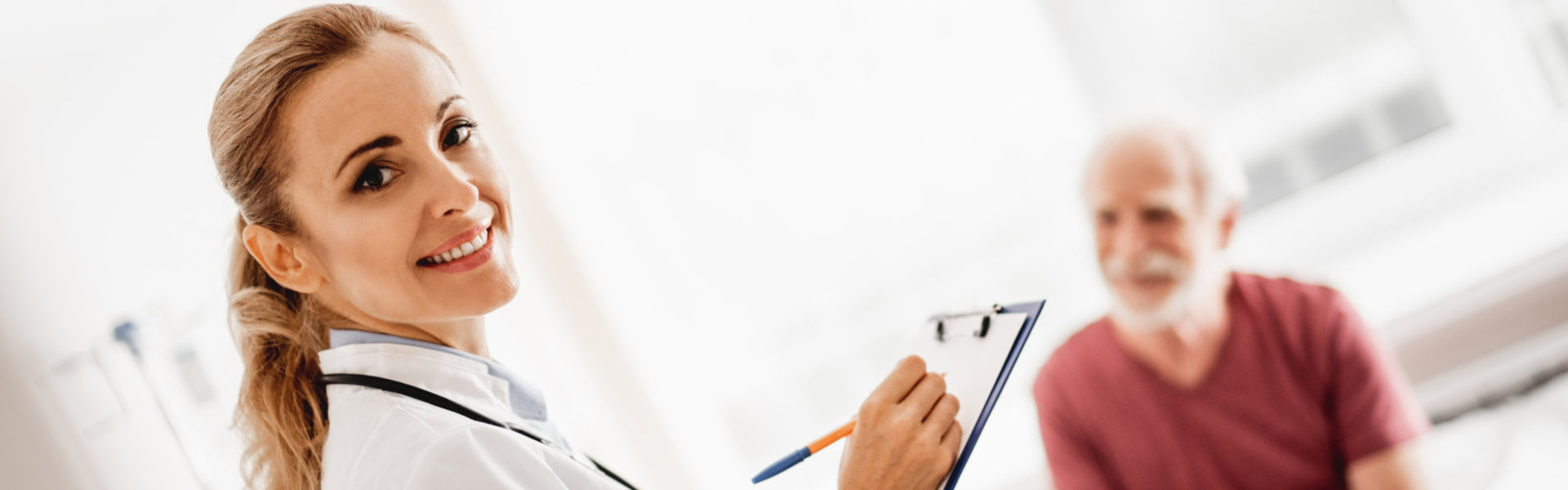 female doctor writing the form with patient in the background